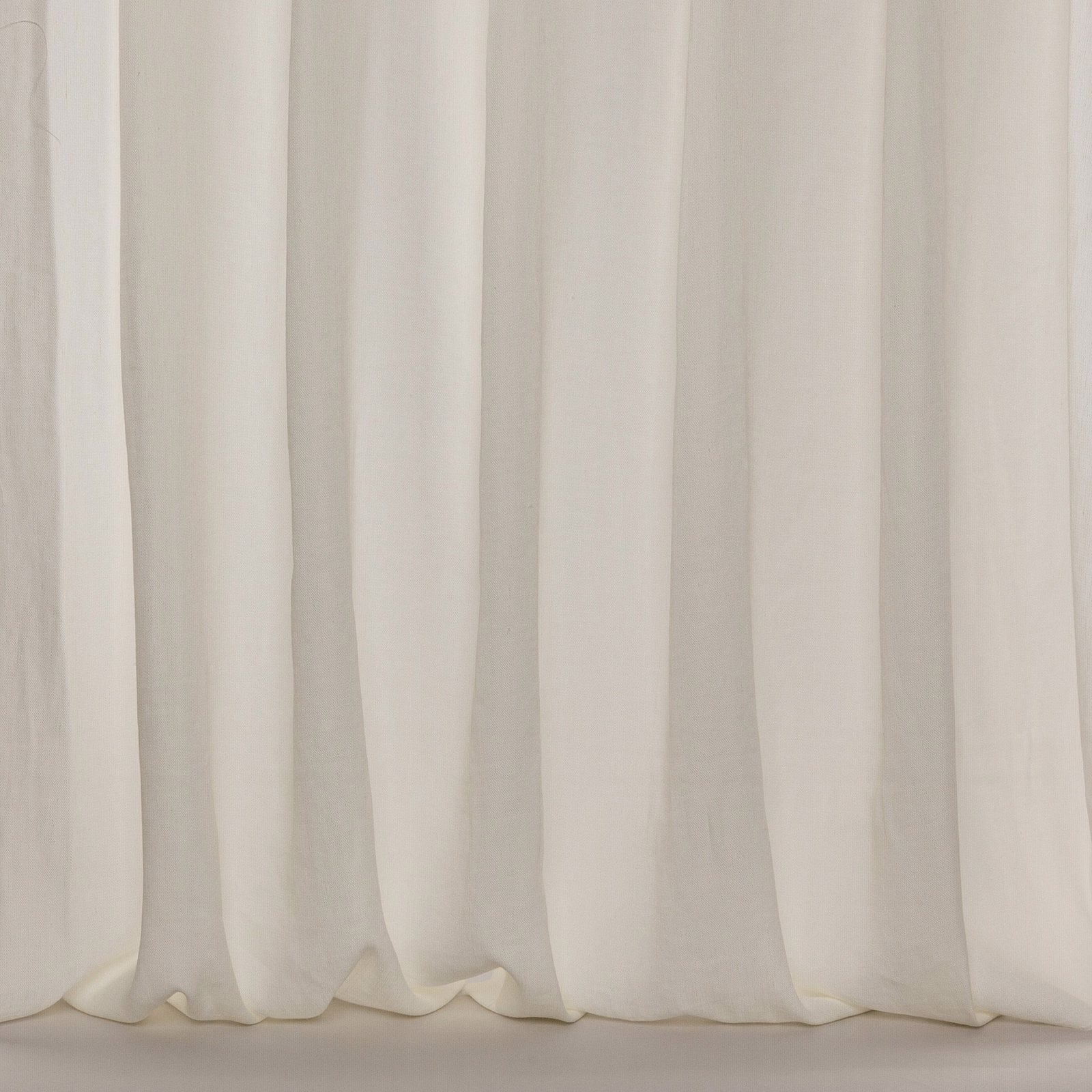 Soft ivory sheer curtain fabric with subtle vertical folds and airy drape