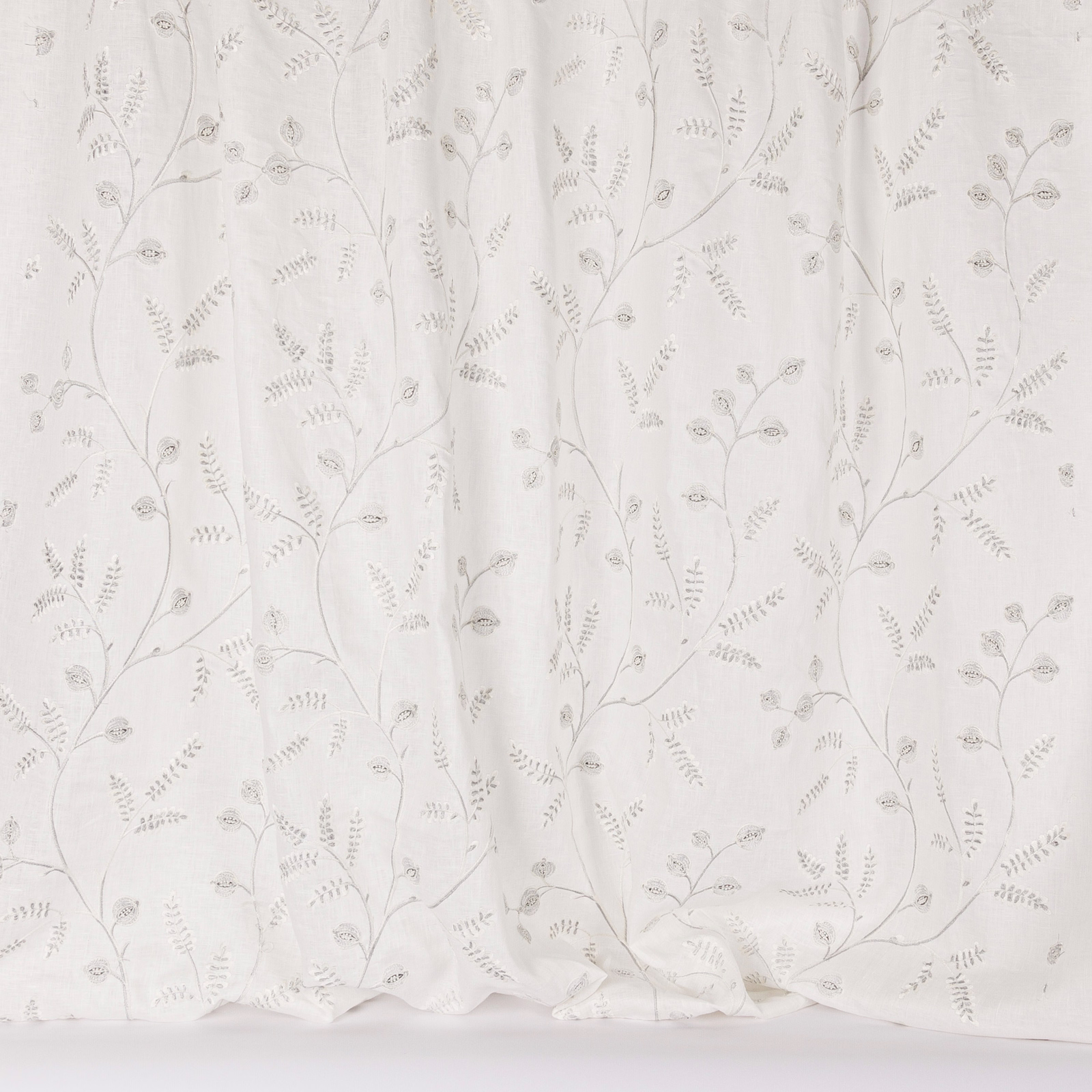 Sheer white fabric with delicate silver vine embroidery and tiny leaf motifs