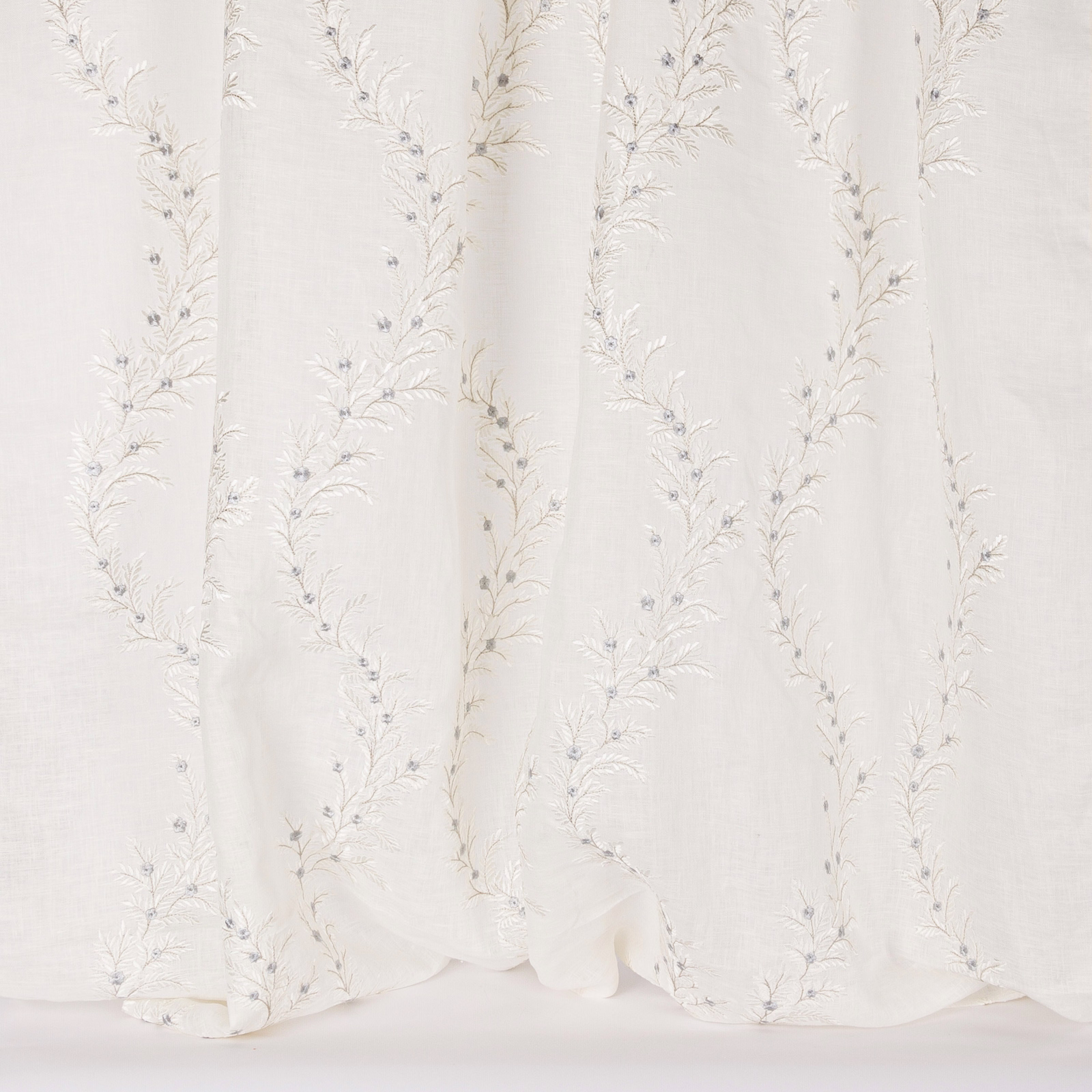Ivory sheer fabric with delicate trailing botanical embroidery and soft vertical folds