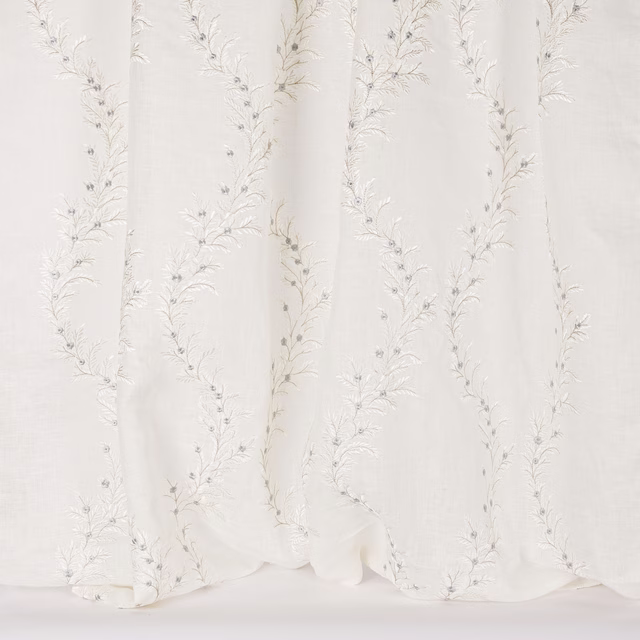 Ivory sheer fabric with delicate trailing botanical embroidery and soft vertical folds