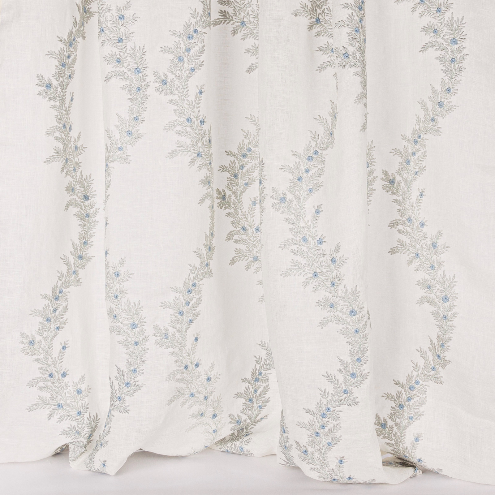 Sheer white fabric with trailing silver-grey floral embroidery and tiny blue buds