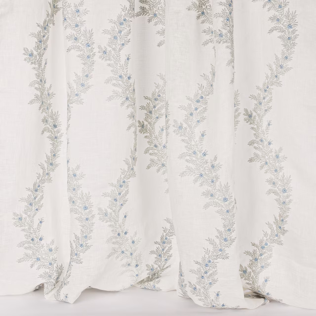 Sheer white fabric with trailing silver-grey floral embroidery and tiny blue buds