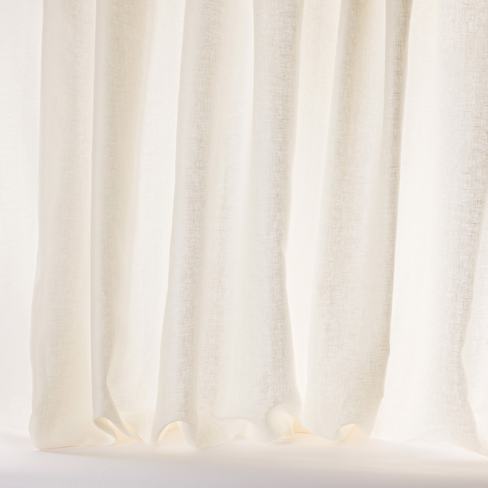 Sheer ivory linen curtains with a soft textured weave and gentle vertical folds