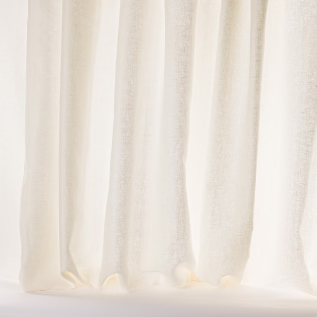 Sheer ivory linen curtains with a soft textured weave and gentle vertical folds