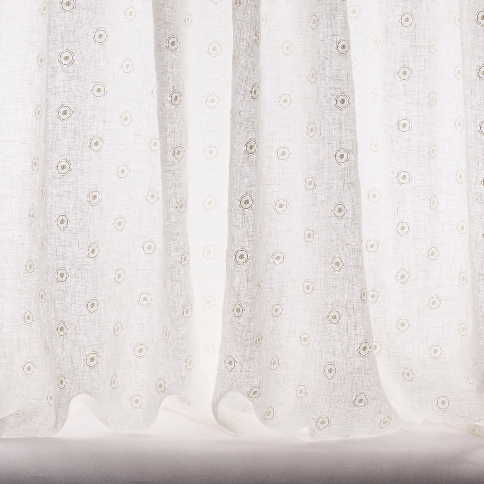 Sheer ivory fabric with small circular motif and soft woven texture