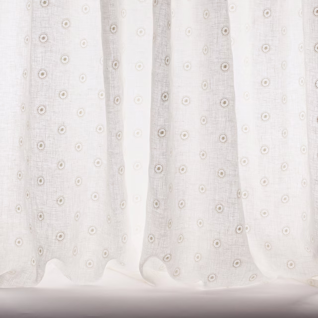 Sheer ivory fabric with small circular motif and soft woven texture
