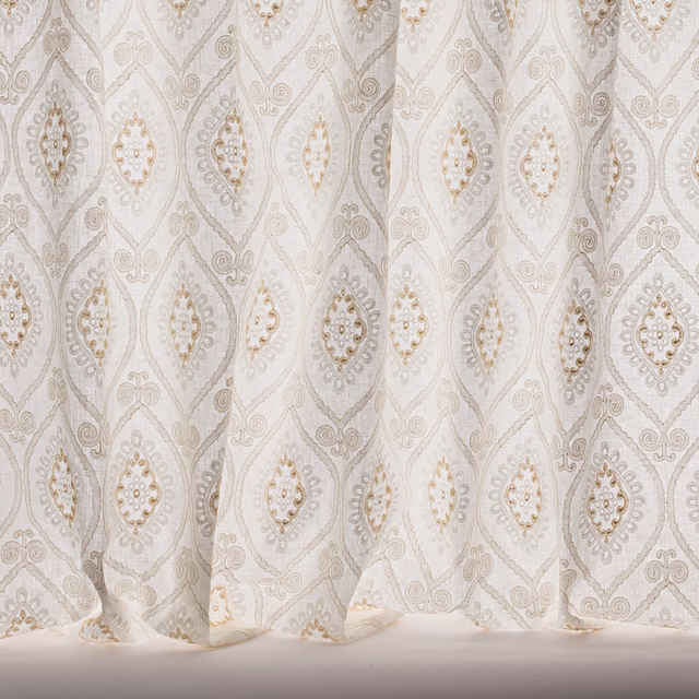 Pale beige sheer curtain fabric with repeating diamond damask motif and subtle gold accents
