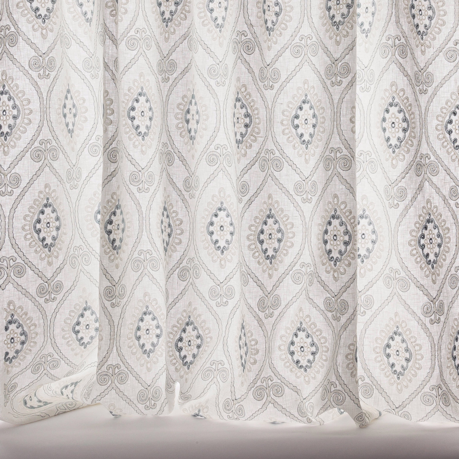 Sheer damask curtain fabric in soft old blue and ivory with diamond motifs