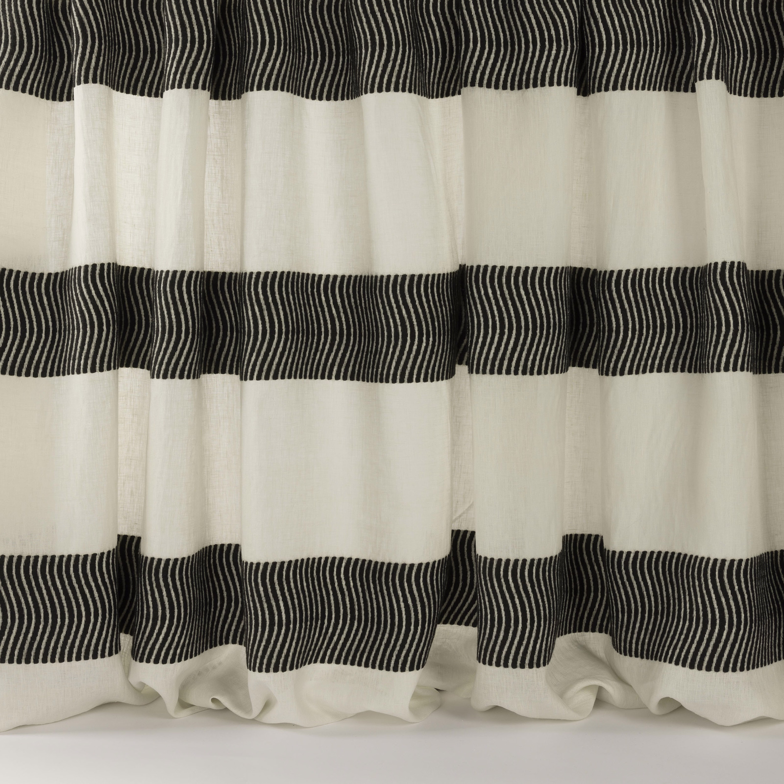 Black fine-striped bands on an ivory woven fabric draped in wide folds