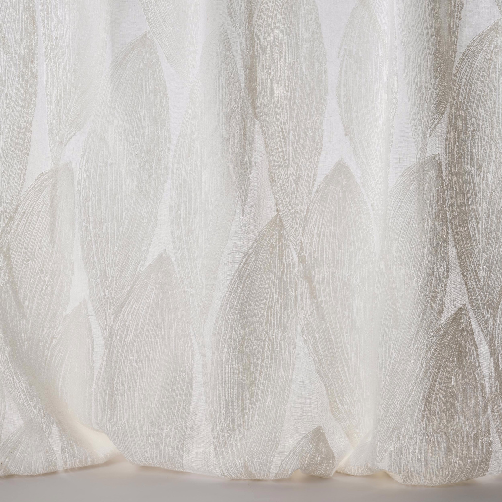 Sheer ivory fabric with large tonal leaf motifs and a softly textured weave.
