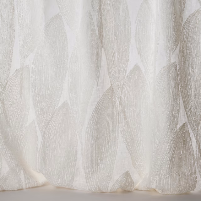 Sheer ivory fabric with large tonal leaf motifs and a softly textured weave.