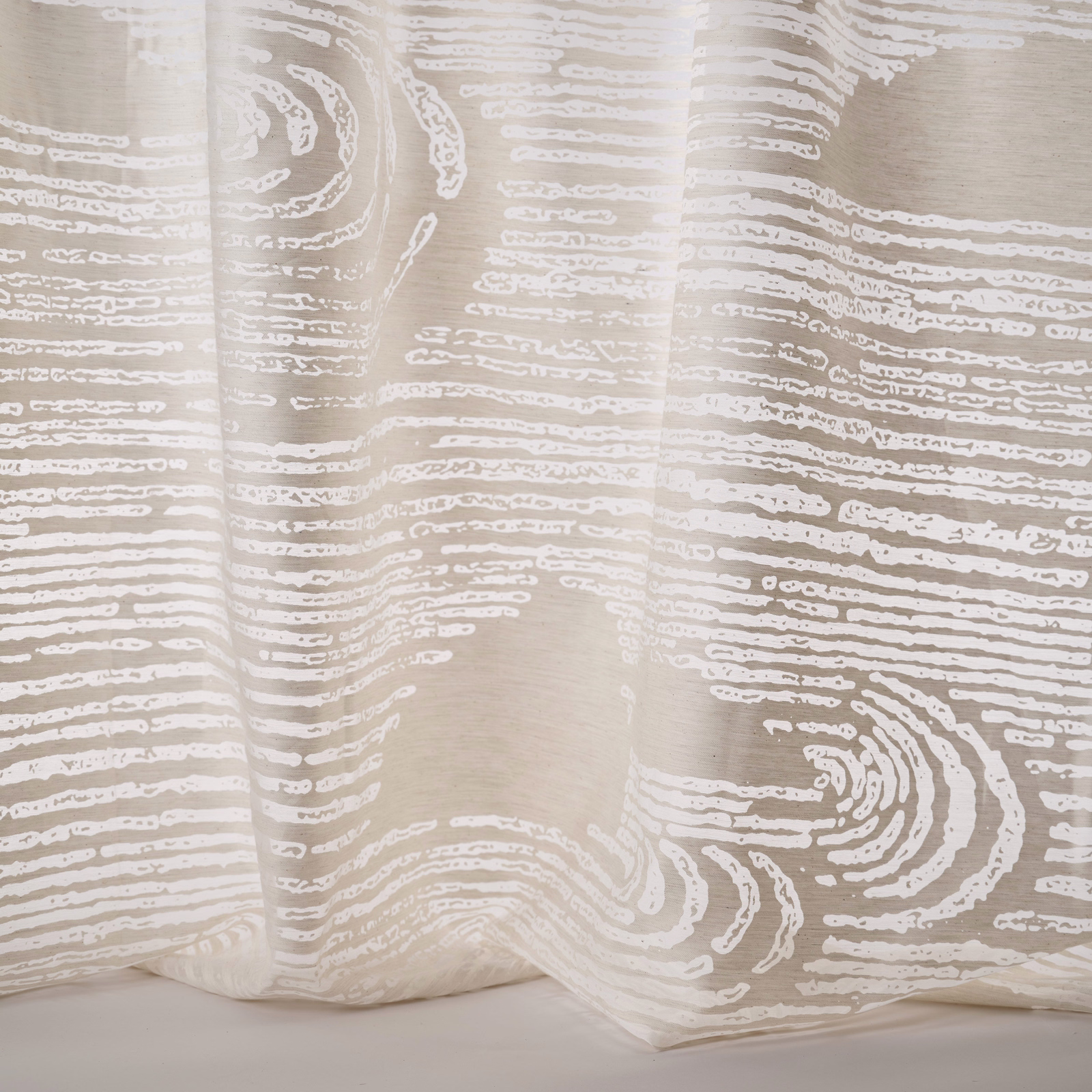 Pale sand abstract patterned fabric with flowing white linear motif and soft drape