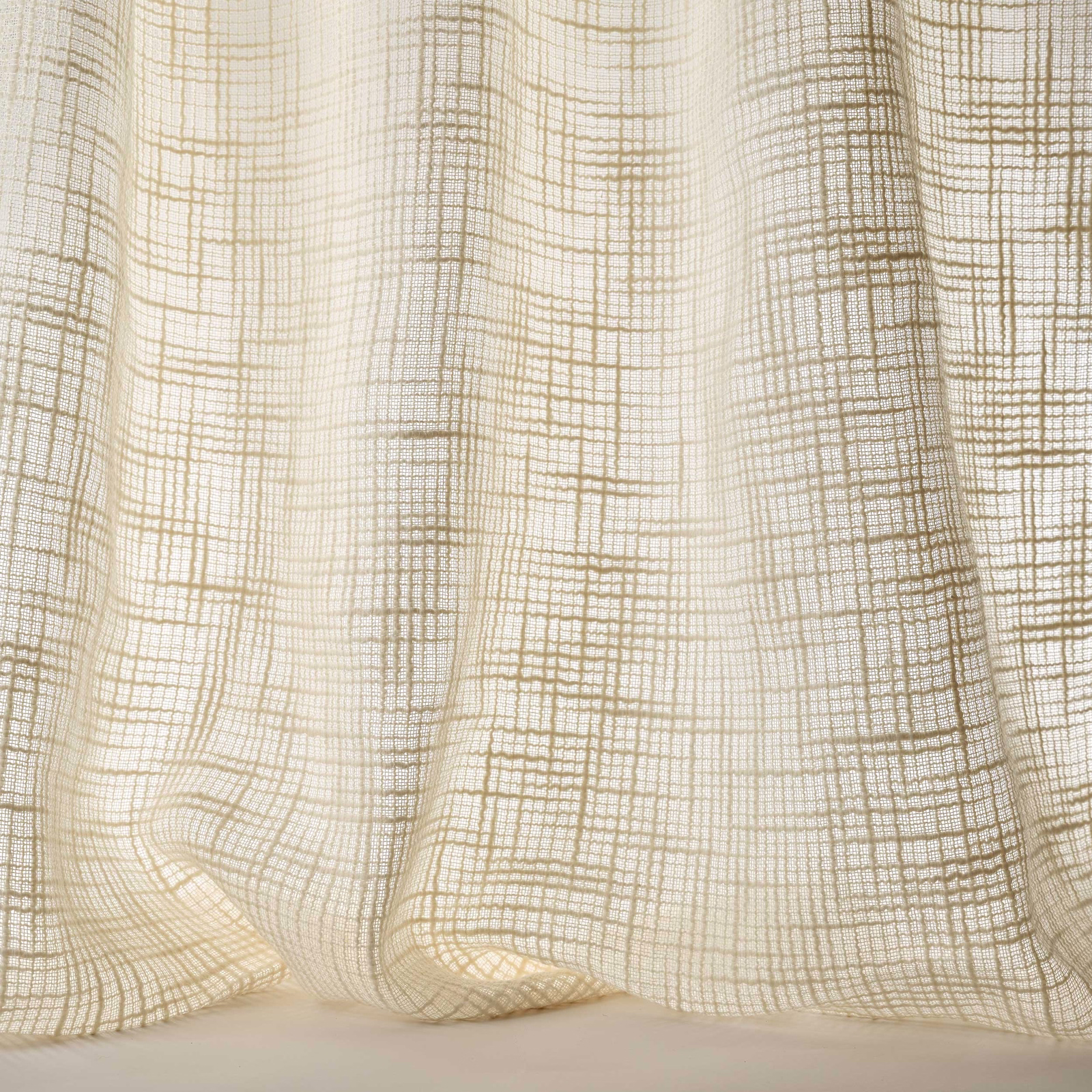 Cream woven fabric with fine beige grid texture draped in soft folds