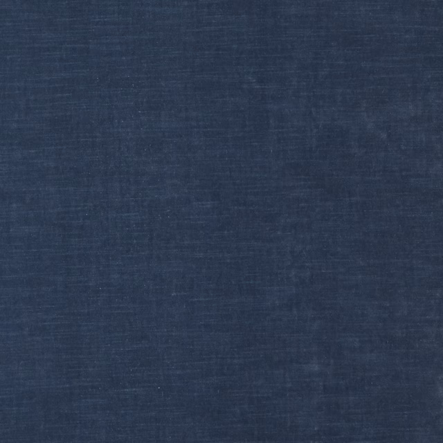 Close-up of a muted denim-blue plain woven fabric with a softly mottled texture
