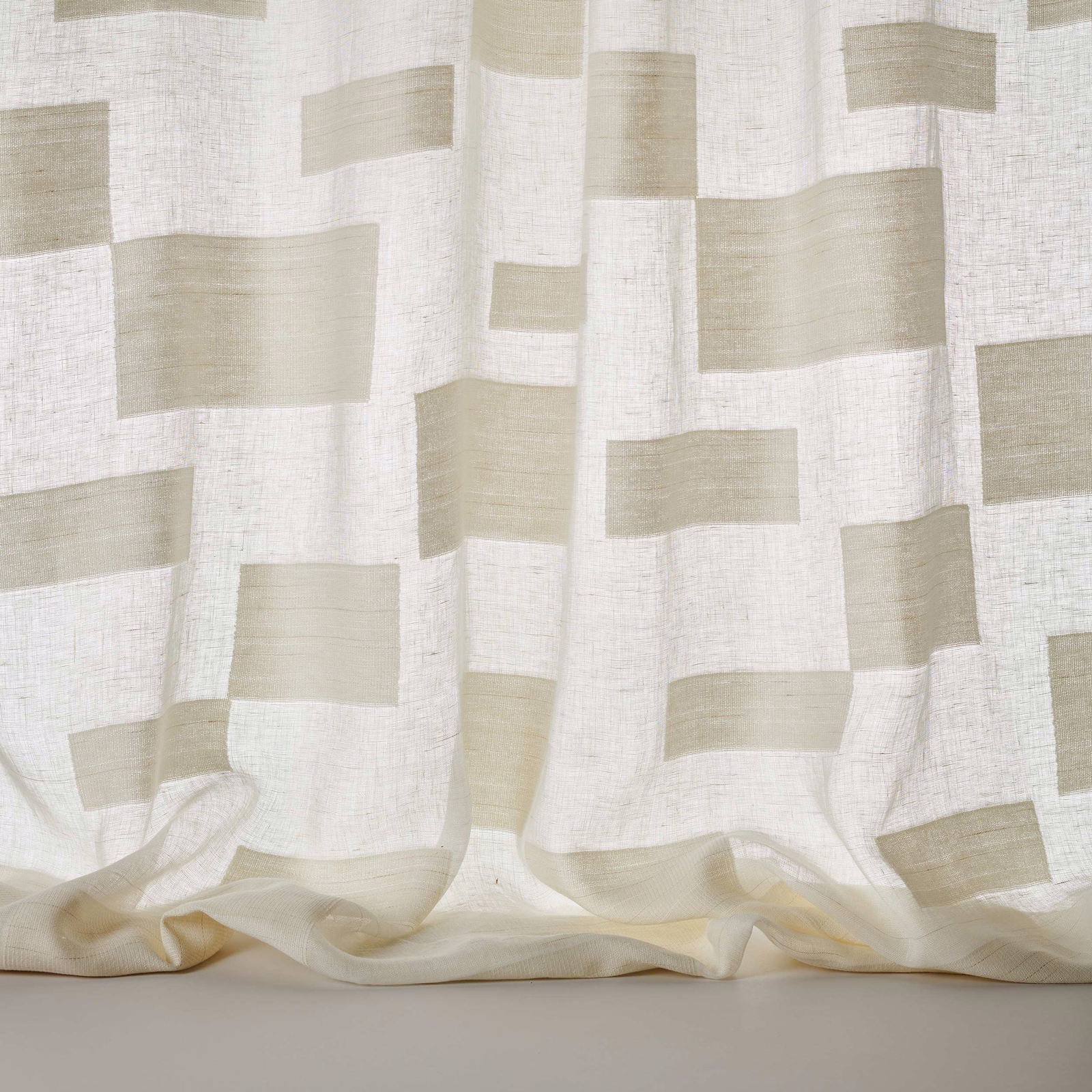Pale cream geometric block fabric with a soft linen texture and flowing drape