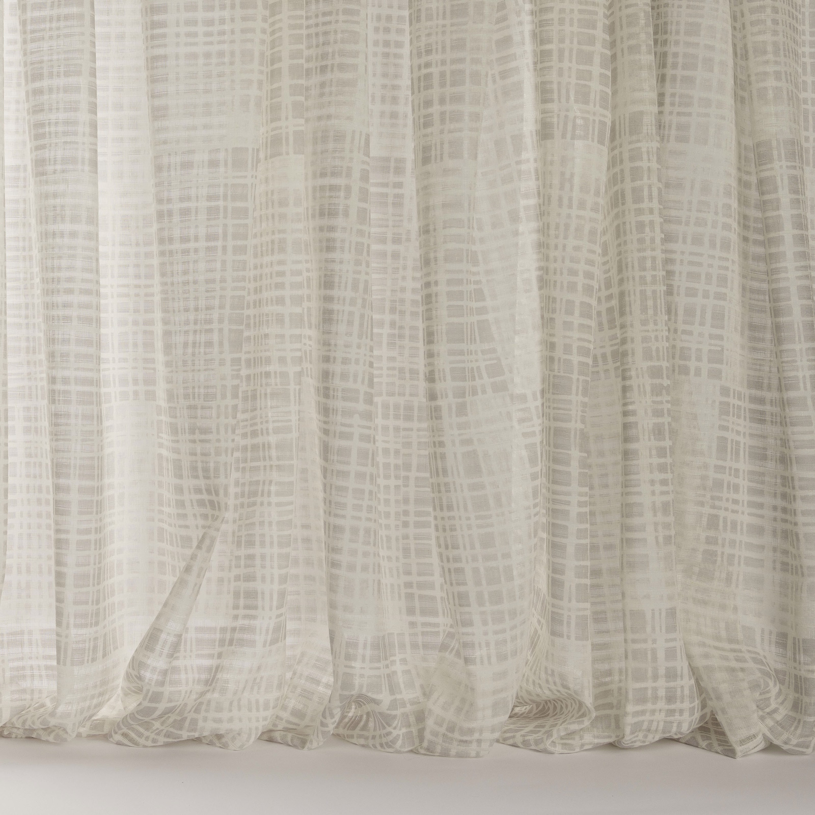 Pale ivory-beige sheer fabric with a fine abstract grid pattern and soft drape