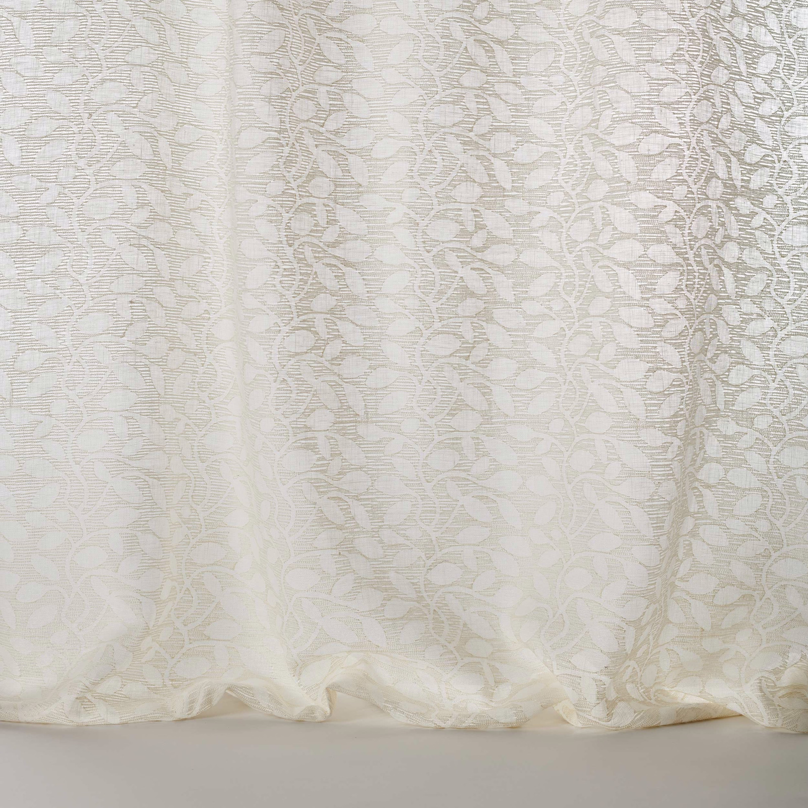 Ivory sheer fabric with a leaf-like jacquard pattern and soft drape