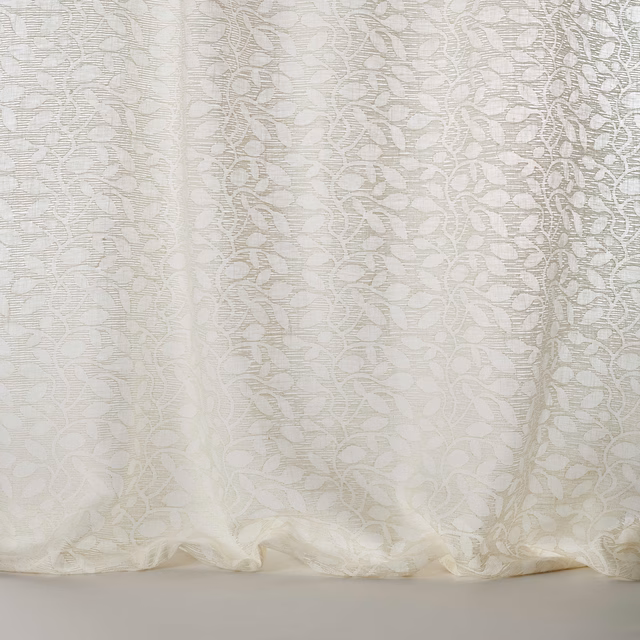 Ivory sheer fabric with a leaf-like jacquard pattern and soft drape
