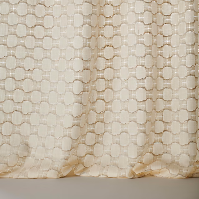 Cream textured fabric with small geometric woven motif and soft drape