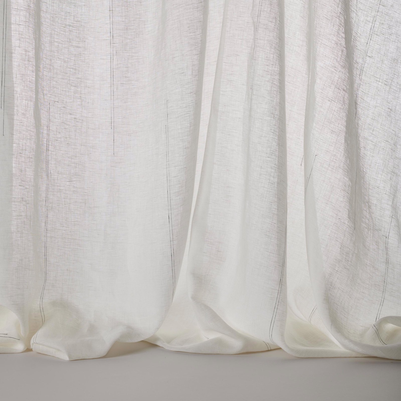 Soft white linen blend curtain fabric with faint vertical stripe texture and relaxed drape