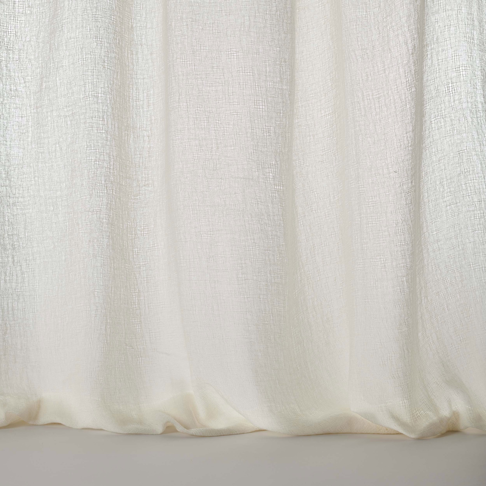 Pale warm cream woven fabric with soft vertical drape and textured finish
