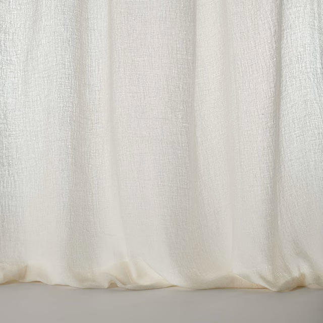 Pale warm cream woven fabric with soft vertical drape and textured finish