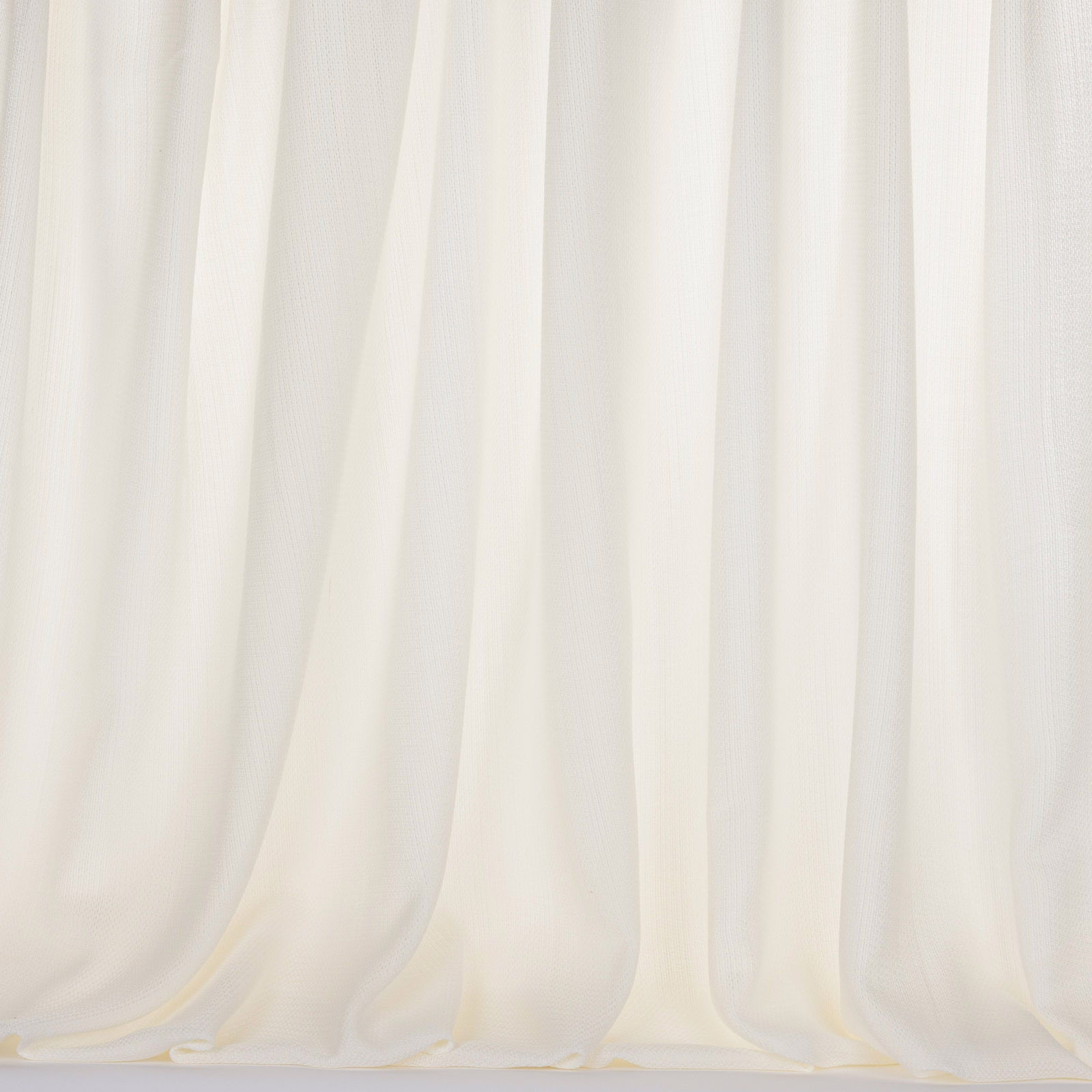 Soft ivory bone curtain fabric hanging in gentle vertical folds