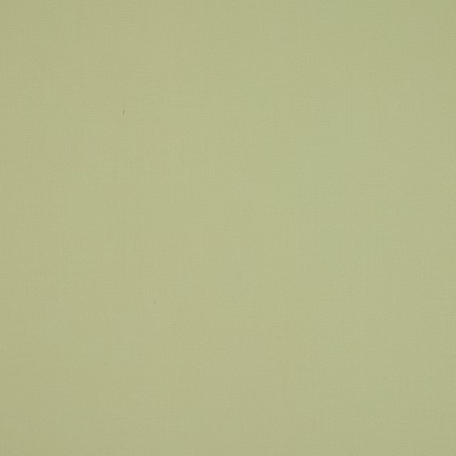 Plain soft tilleul green cotton fabric swatch with a smooth matte finish