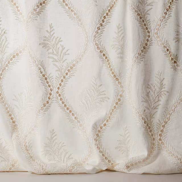 Ivory sheer fabric with embroidered diamond lattice and botanical sprigs