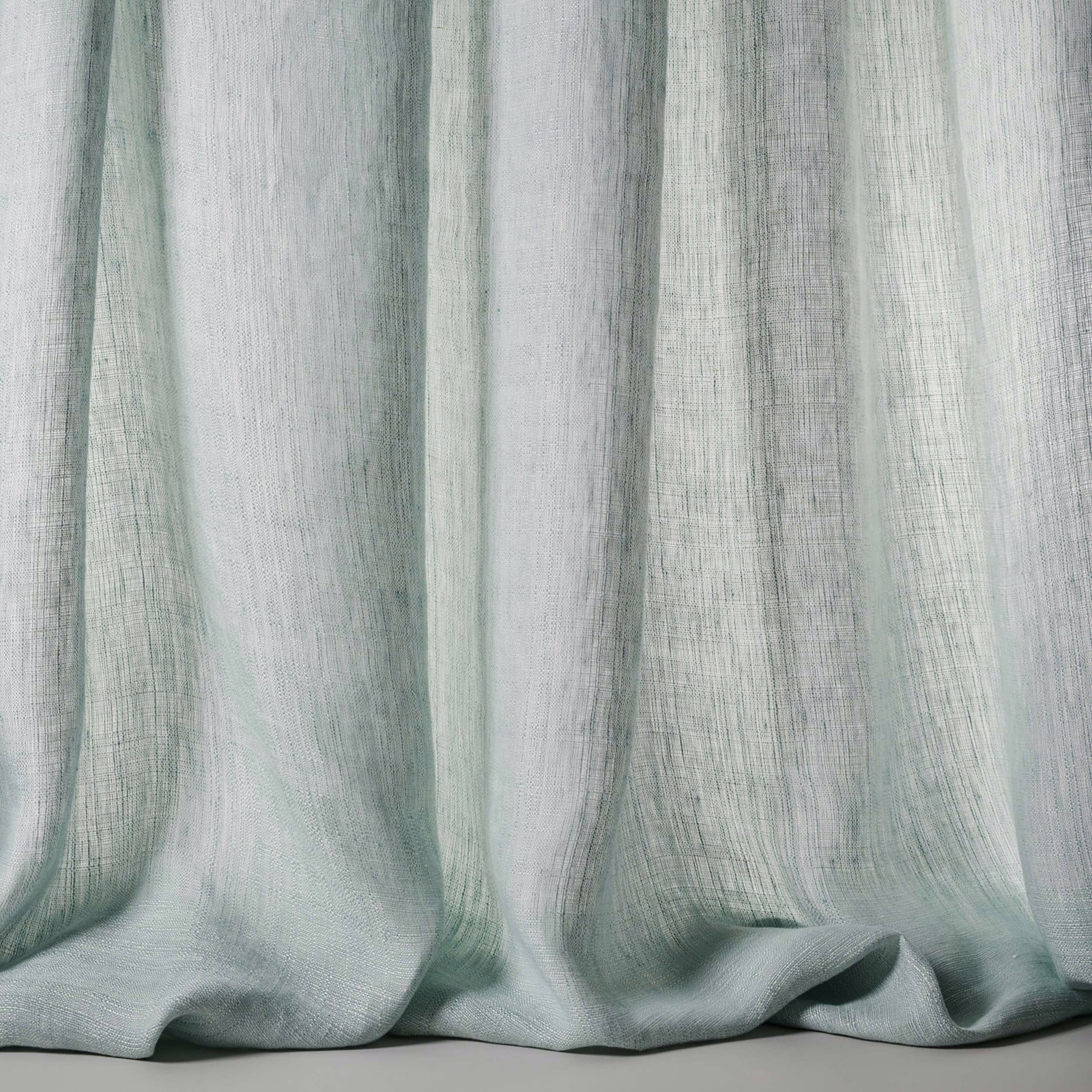 Soft pale blue linen sheer fabric with a subtle slubby weave and hanging folds