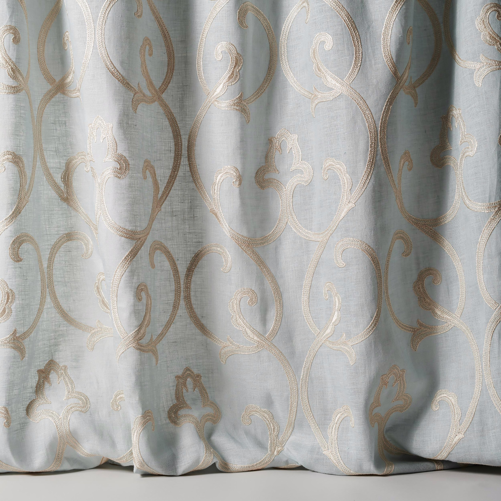Pale dusty blue sheer fabric with large scrolling damask in ivory-beige