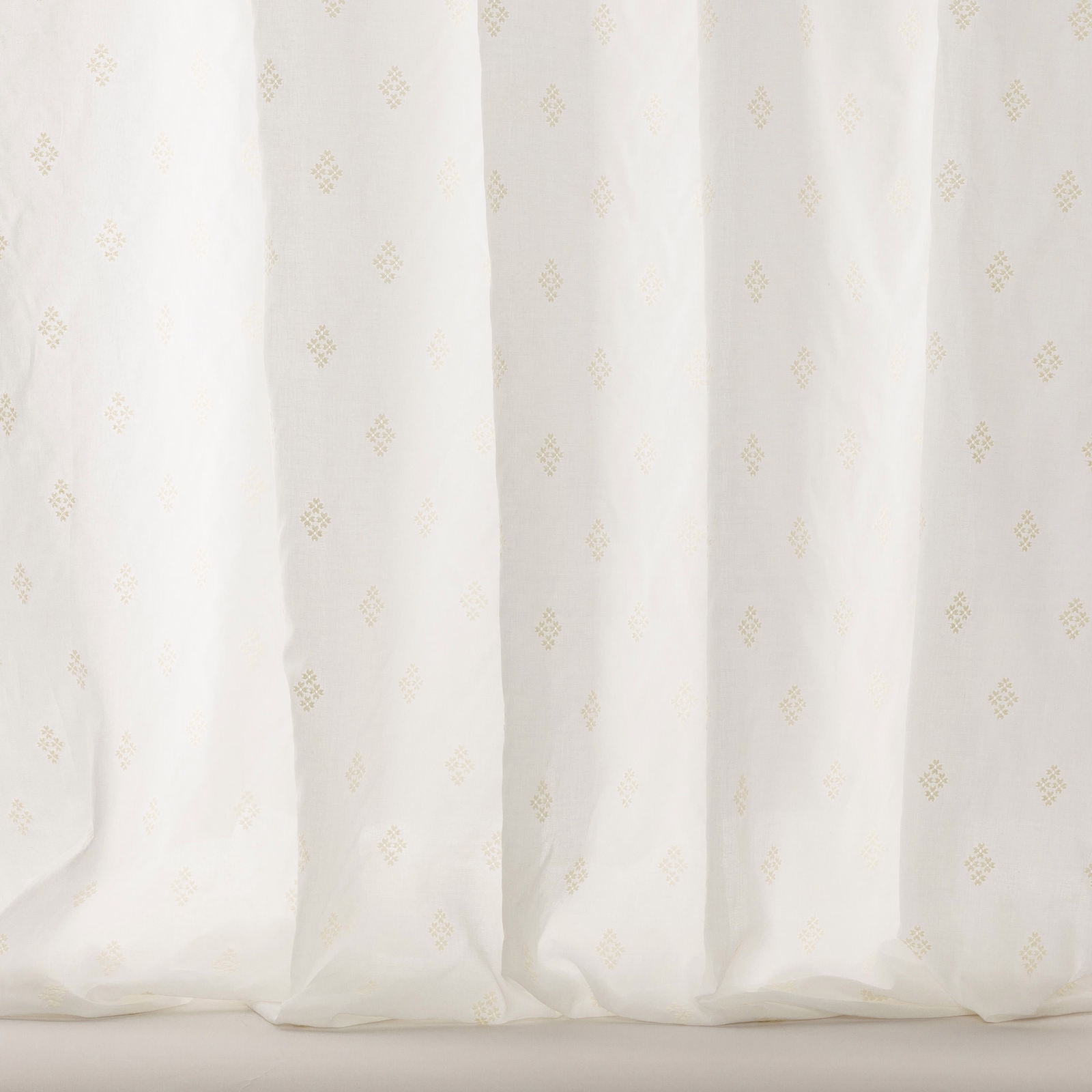 Sheer white cotton fabric with tiny pale gold scattered motifs