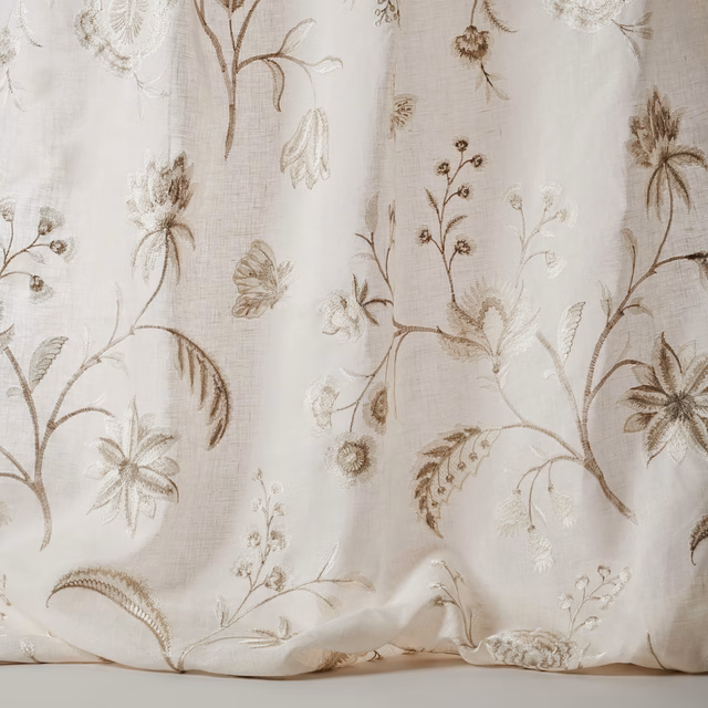 Ivory sheer fabric with large embroidered floral stems and taupe-brown detail