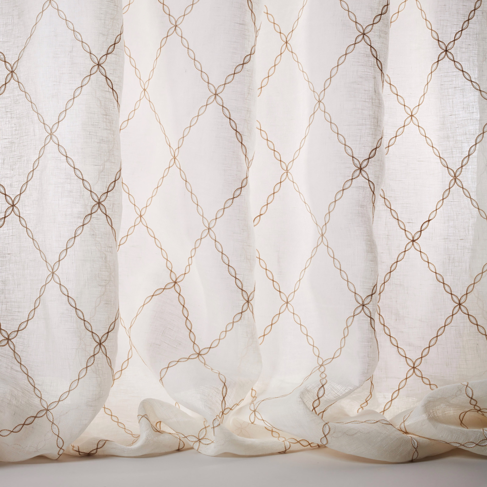 Sheer ivory linen fabric with warm beige looping lattice pattern
