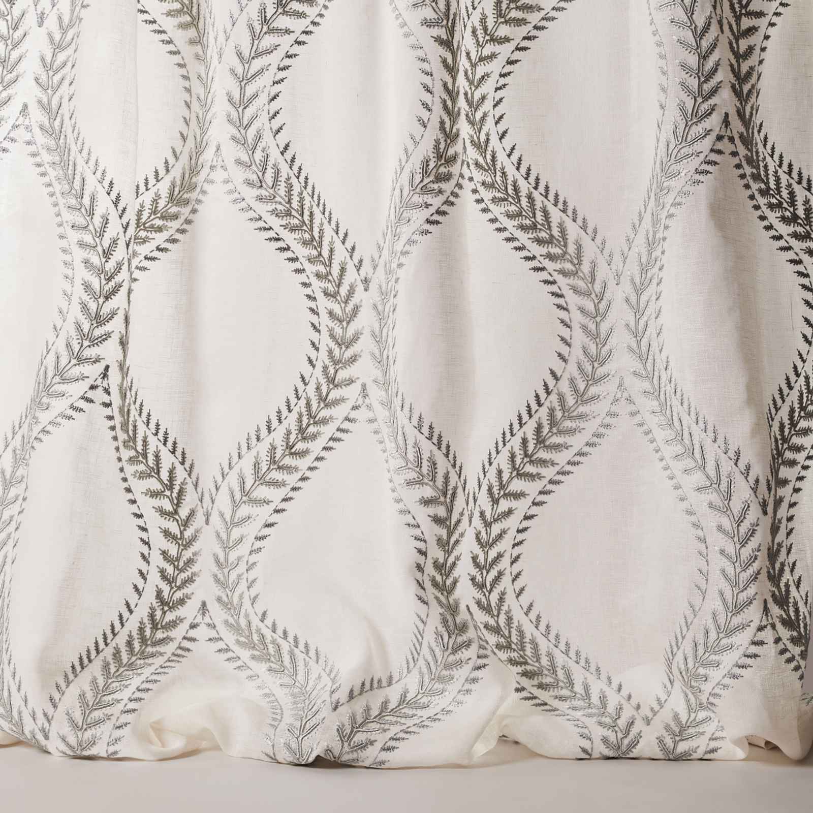 Ivory sheer fabric with large embroidered leaf loops in muted blue-grey