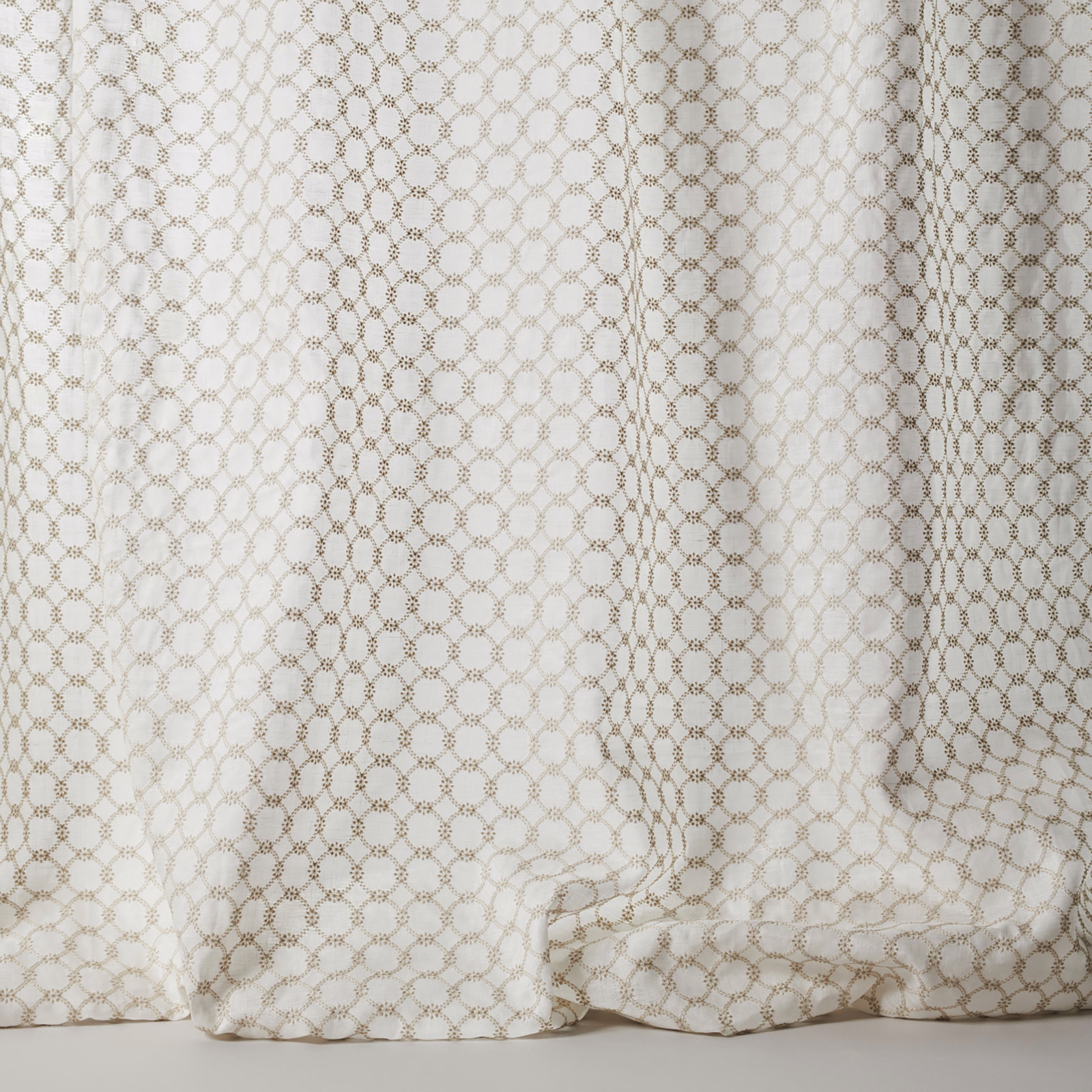 Cream sheer fabric with small taupe geometric lattice and soft drape