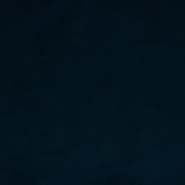 Close-up of a deep ink-blue plain cotton fabric swatch with a matte finish.