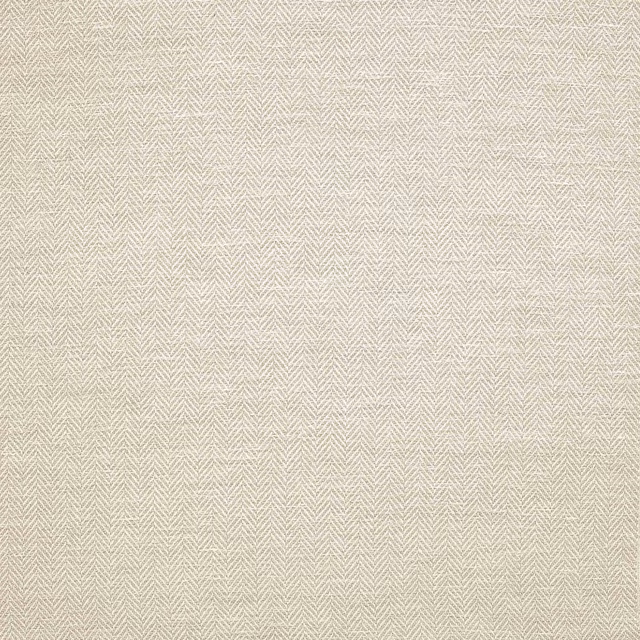 Close-up of pale warm cream herringbone woven fabric with fine texture