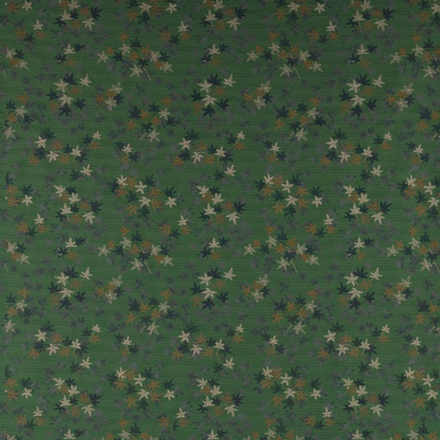 Emerald green patterned fabric with small scattered leaf flowers and muted cream accents