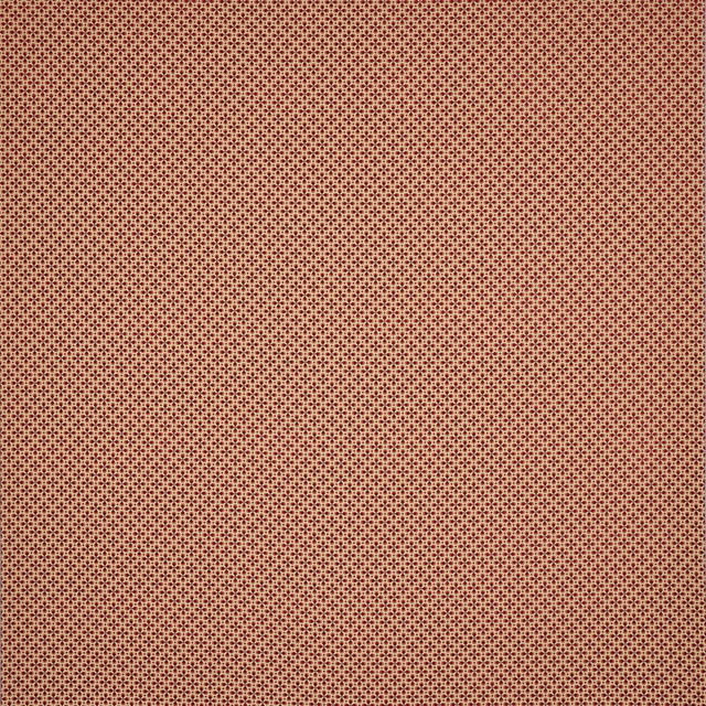 Close-up of tiny repeating terracotta-red woven dots on a textured fabric swatch