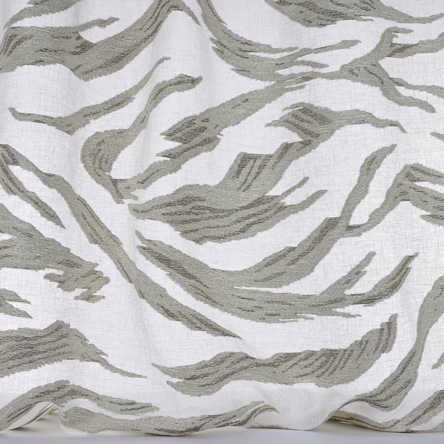 White fabric with large olive-grey abstract brushstroke pattern and textured weave