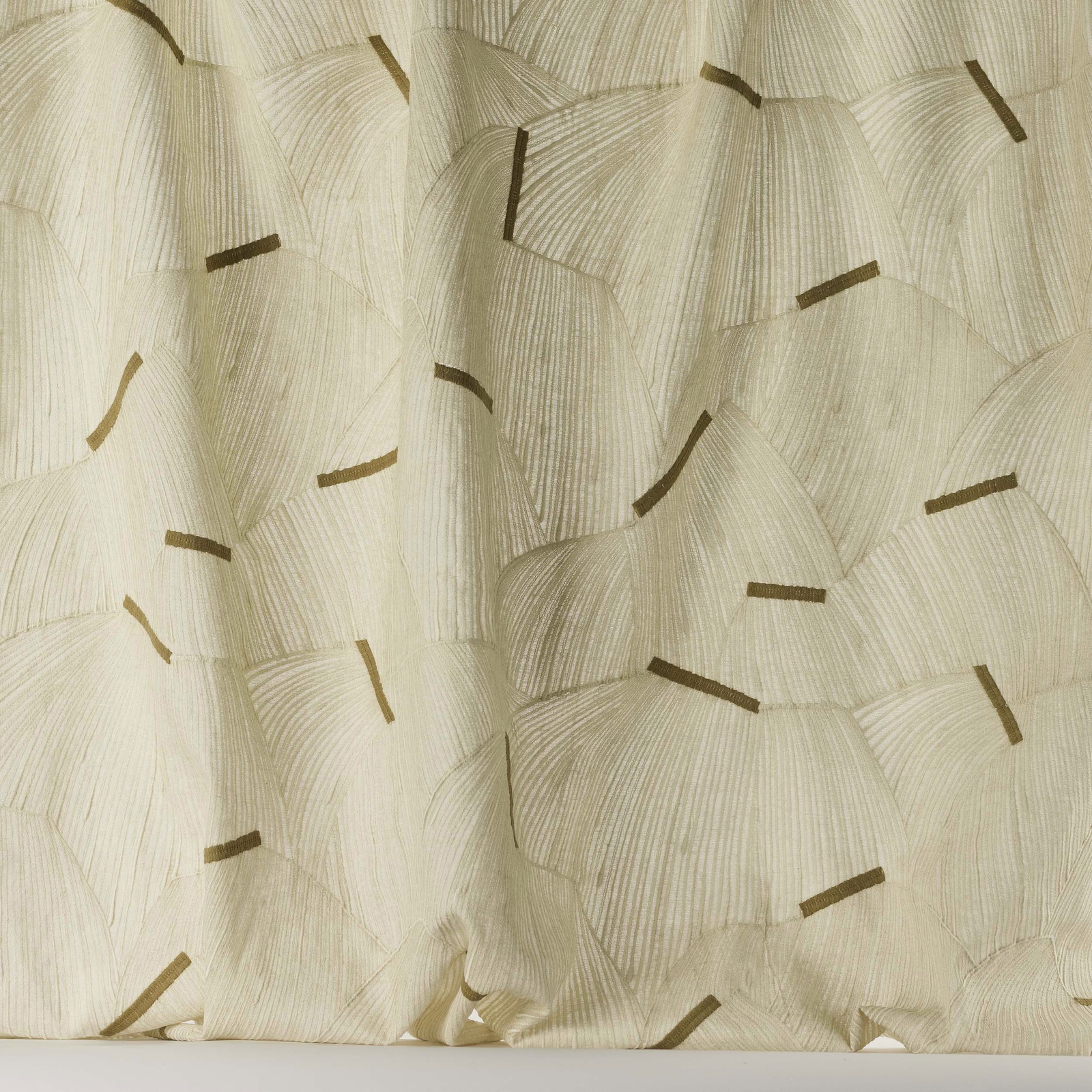 Cream-sand woven fabric with scattered tan geometric marks and soft drape