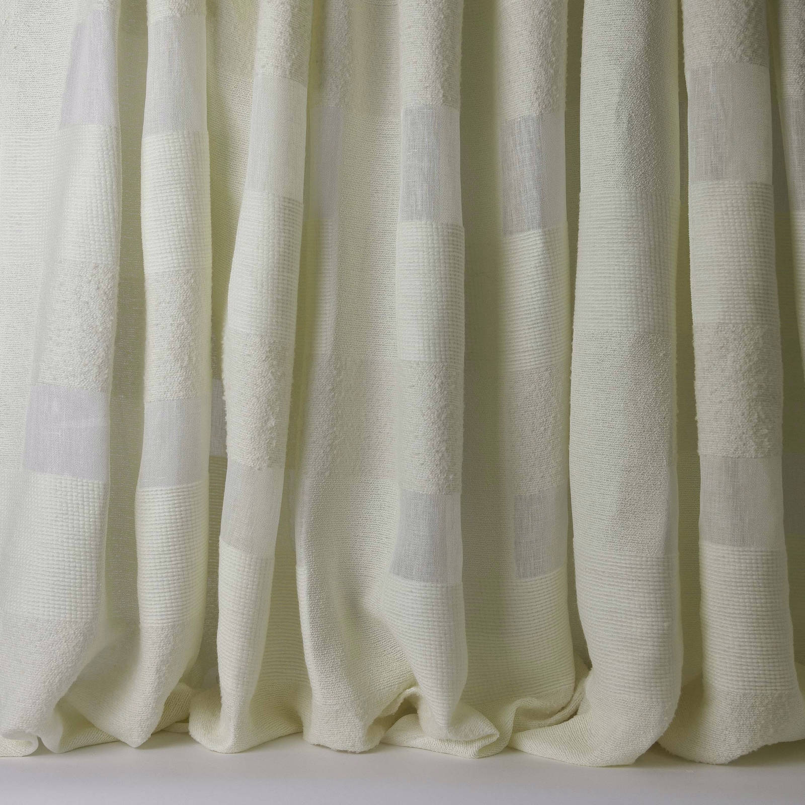 Cream woven curtain fabric with broad tonal stripes and soft textured folds