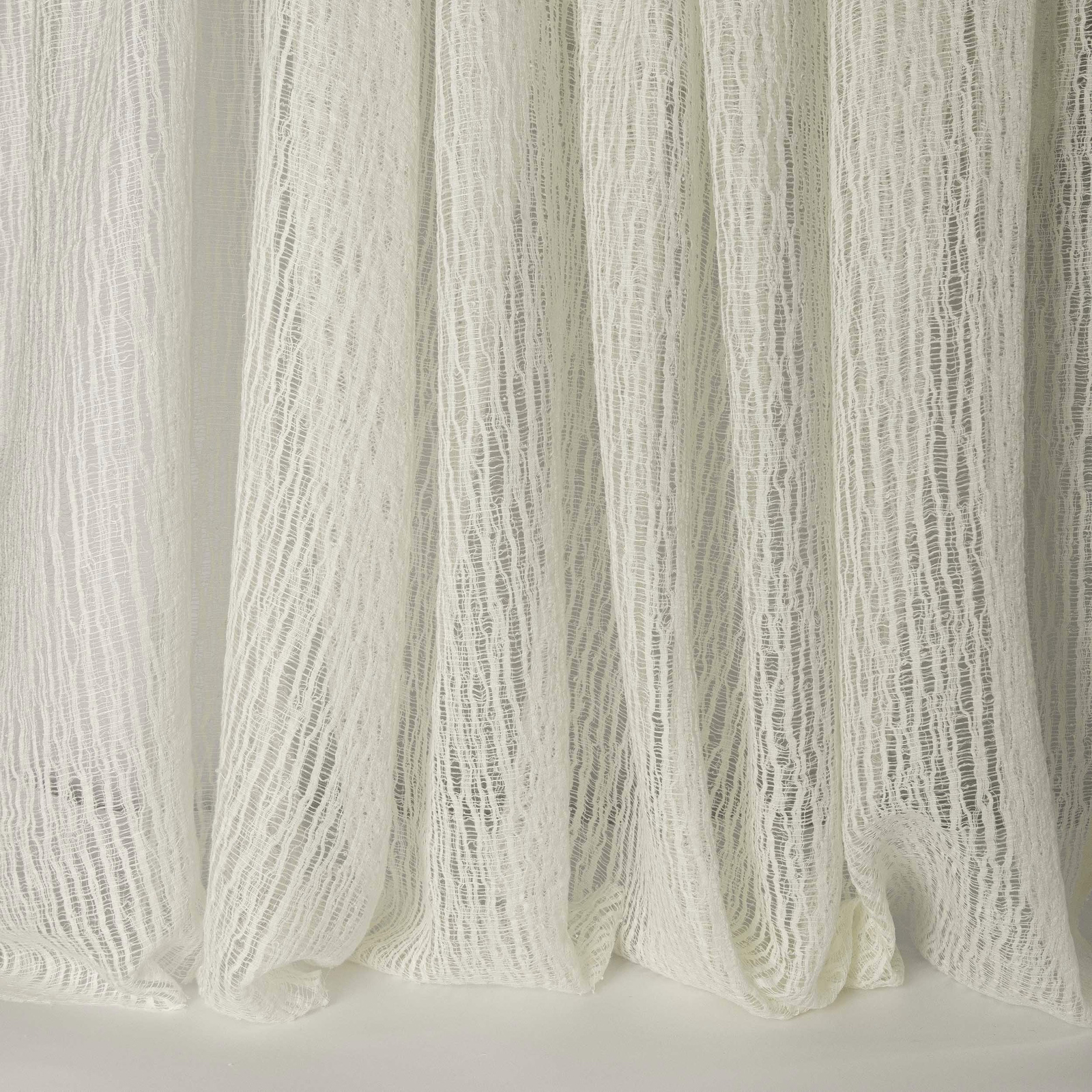 Sheer ivory-white linen-look fabric with a crinkled vertical texture and soft folds