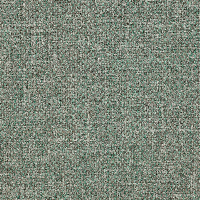 Close-up of a soft sage green woven fabric with a slubby textured surface