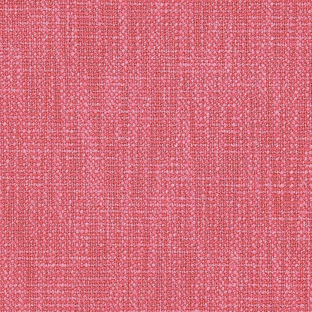 Close-up of a bright raspberry pink textured woven fabric with a pebbled surface