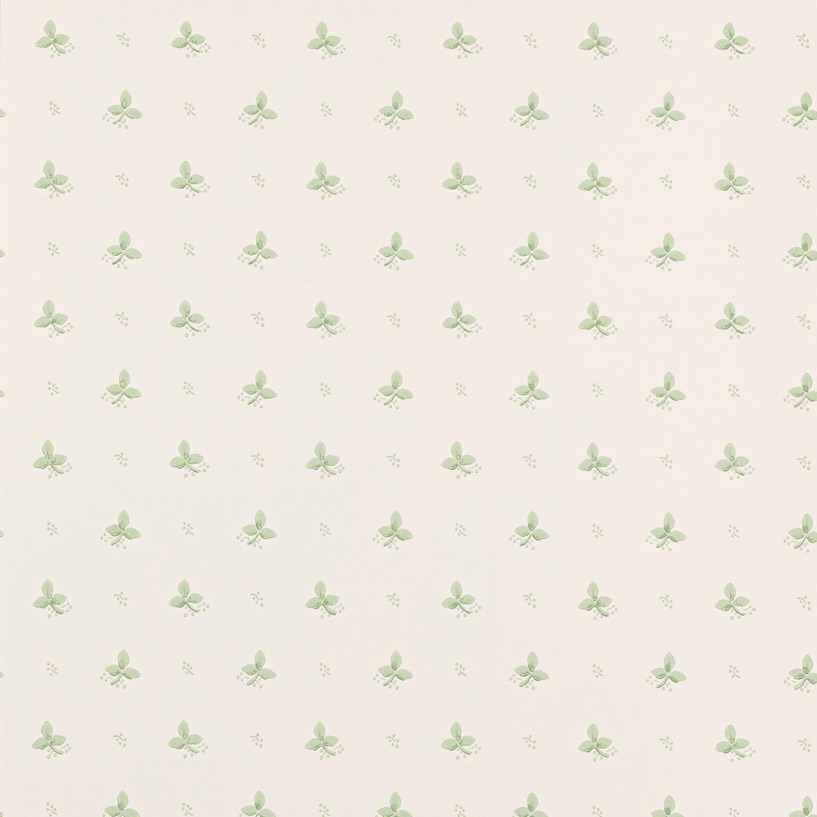 Pale sage three-leaf sprigs and tiny flecks on a warm cream wallpaper ground