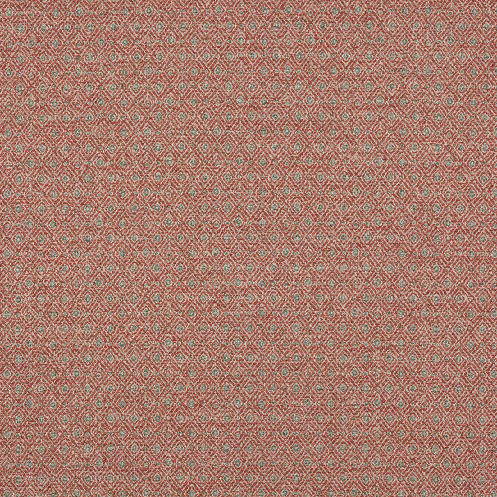 Close-up of small diamond geometric fabric in warm terracotta red with muted green and pale accents