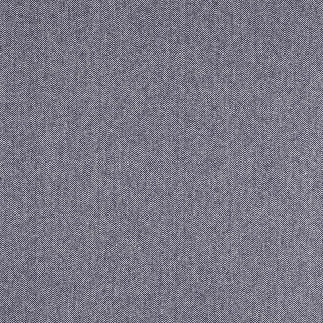 Close-up of muted indigo herringbone woven fabric with fine zigzag texture