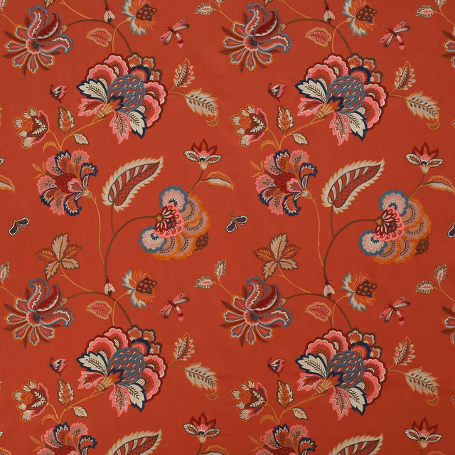 Bold floral fabric on a warm red ground with pink, cream and navy motifs